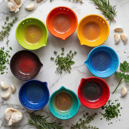 Colorful ceramic herb stripping bowls on a marble surface with herbs and garlic cloves.