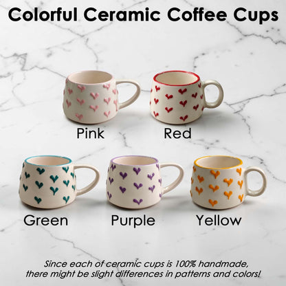 Colorful ceramic coffee cups with heart patterns on a marble surface