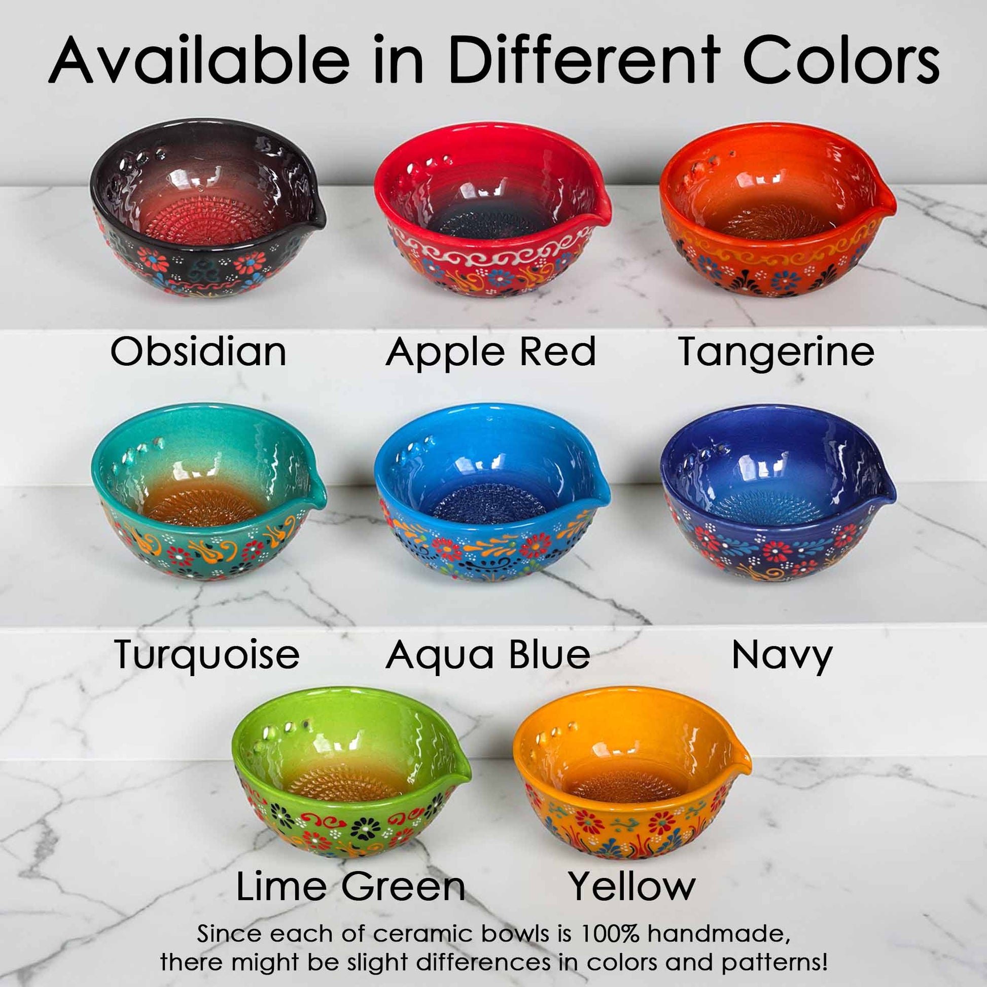 Set of ceramic bowls in various colors on a marble surface