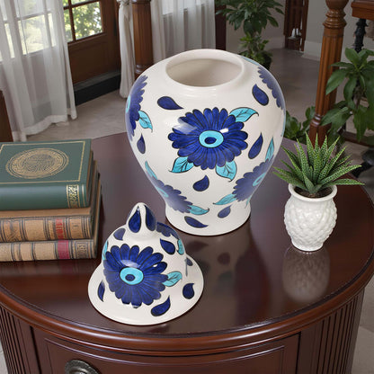 Decorative ceramic jar with blue floral patterns on a wooden table.