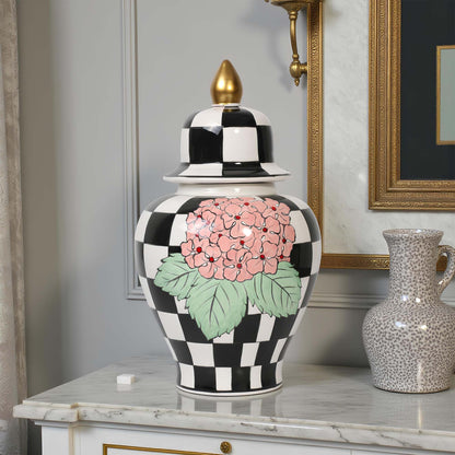 Decorative jar with floral design and checkered pattern on a marble surface.