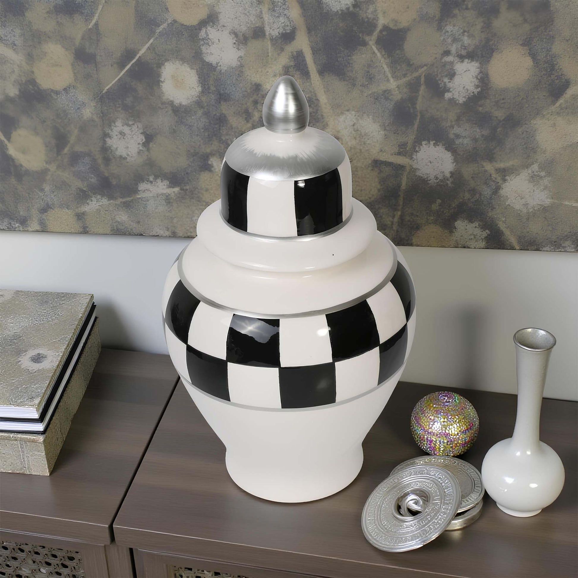 Decorative jar with checkered pattern on a wooden surface with a floral wallpaper background