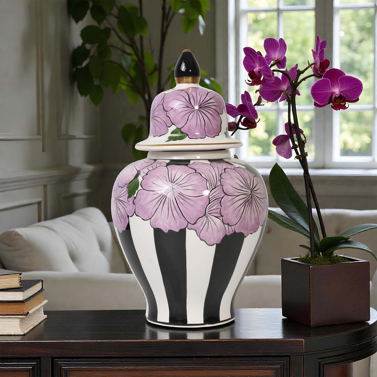 Decorative jar with floral design on a table in a room with a couch and window.