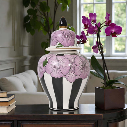 Decorative jar with floral design on a table in a room with a couch and window.