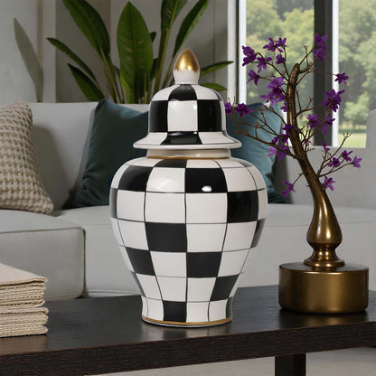 Black and white checkered jar on a table with a gold vase and purple flowers in a living room setting.