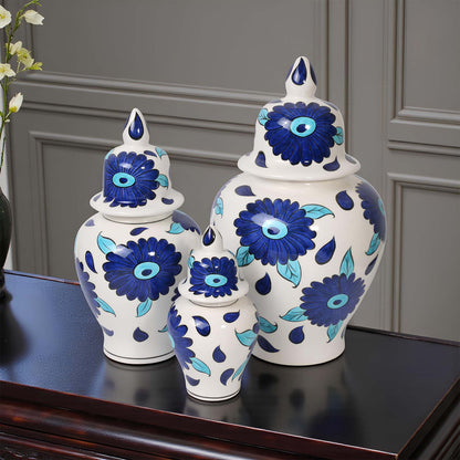 Set of three decorative ceramic jars with blue floral patterns on a dark surface.