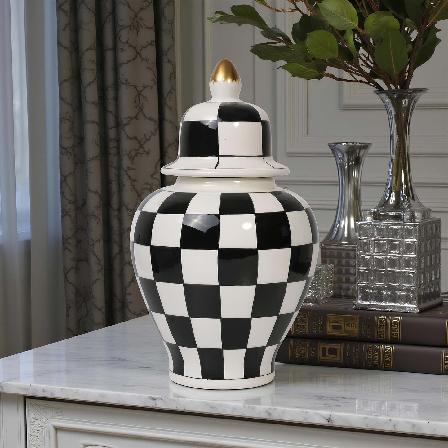 Black and white checkered vase on a marble surface with decorative books and vases in the background.