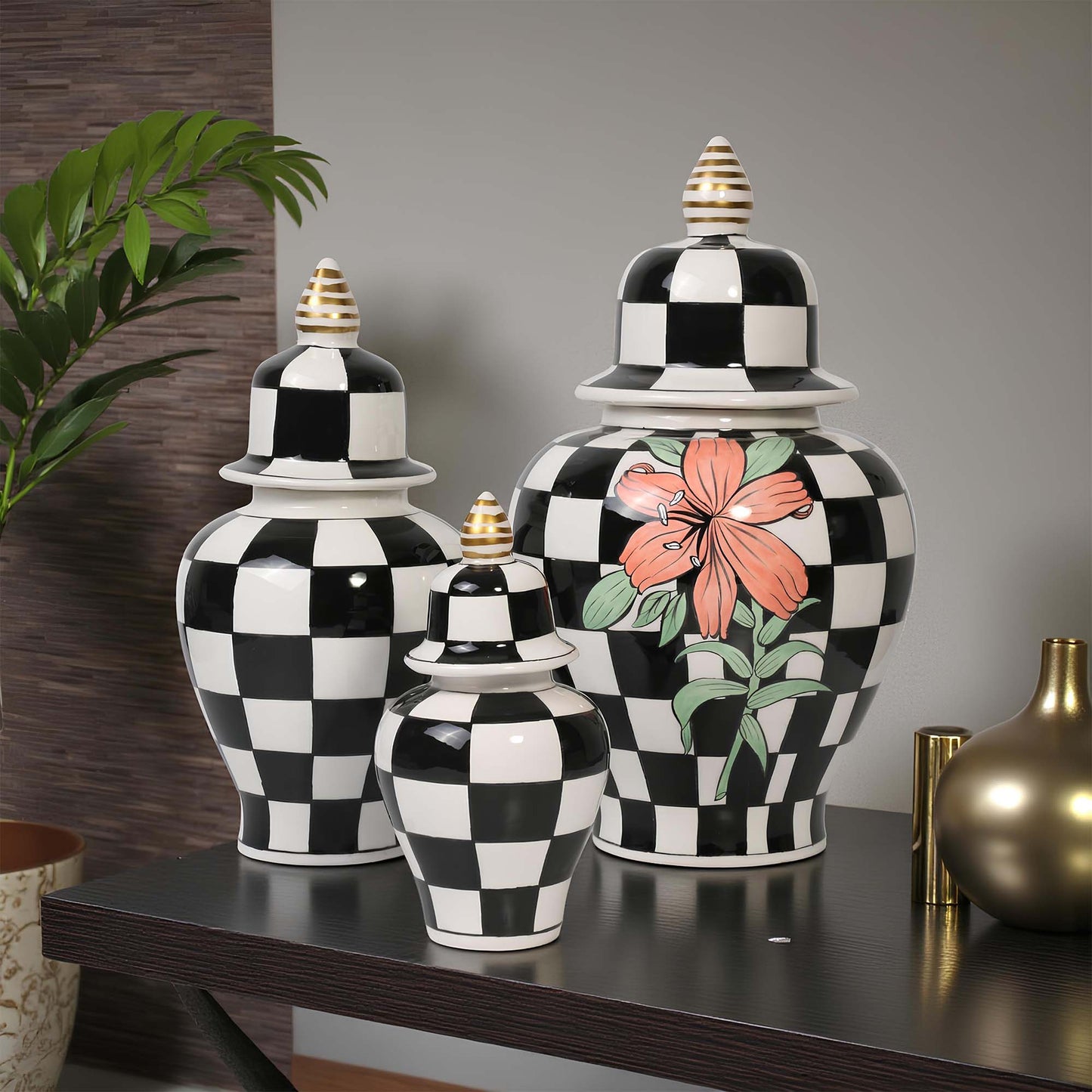 Set of black and white checkered jars with floral design on a table.