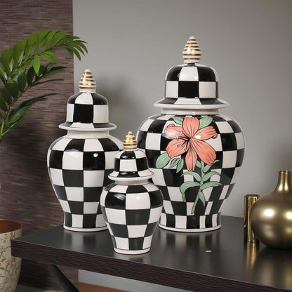 Set of black and white checkered jars with floral design on a table.