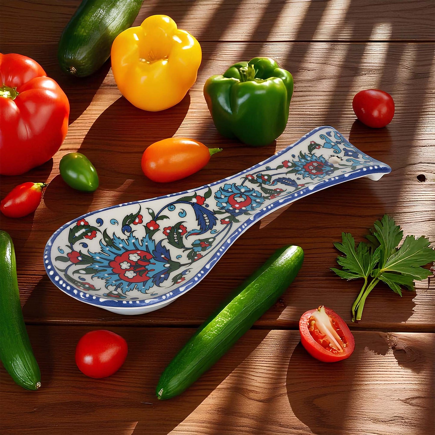 Colorful ceramic spoon rest on a wooden surface with various vegetables around it.