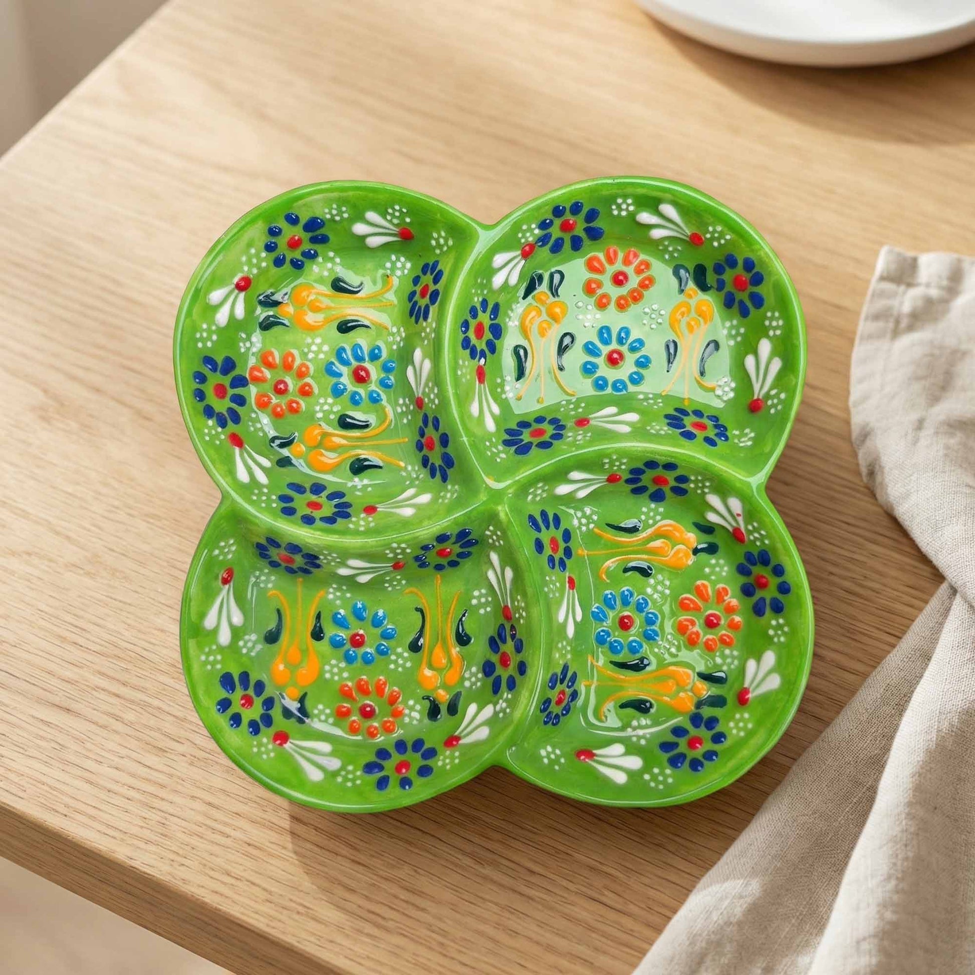 Decorative green snack platter with floral patterns on a wooden surface