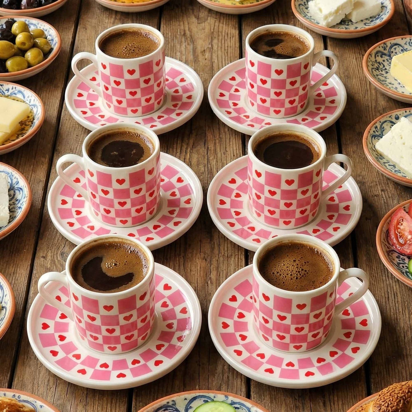 Café au lait in pink cups with heart patterns on wooden table