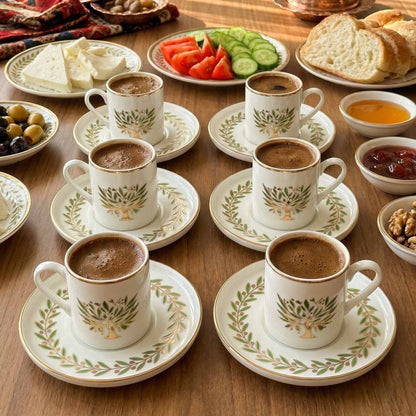 Café au lait cups with saucers on a wooden table with snacks.