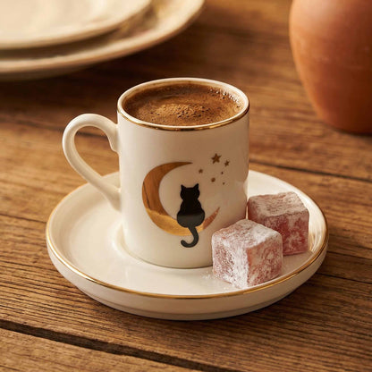 Porcelain mug with a cat design on a saucer with Turkish delight on a wooden table