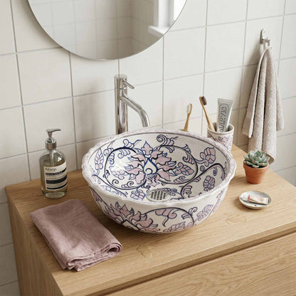 Bathroom sink with decorative basin, toiletries, and a mirror.