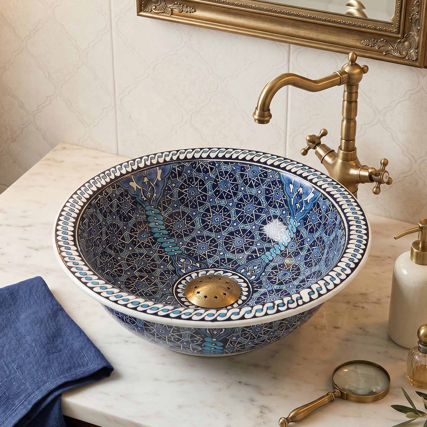 Decorative blue mosaic sink with gold faucet in a bathroom setting