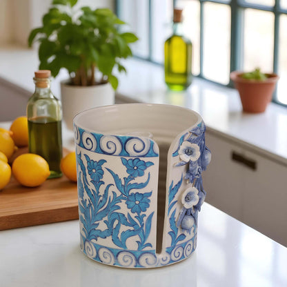 Ceramic paper towel holder with blue floral patterns on a kitchen counter