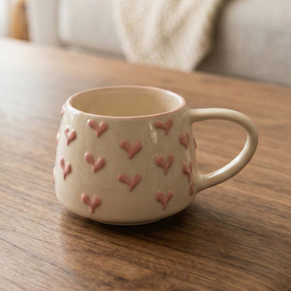 Ceramic mug with heart patterns on a wooden table