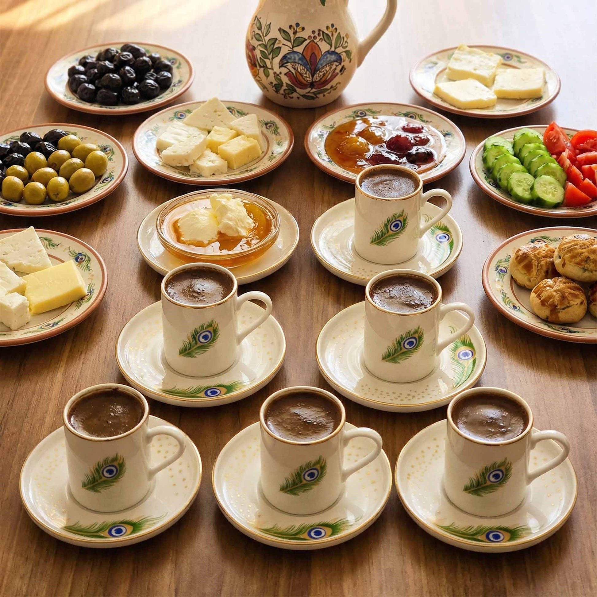 Café con leche cups with saucers on a wooden table with snacks.