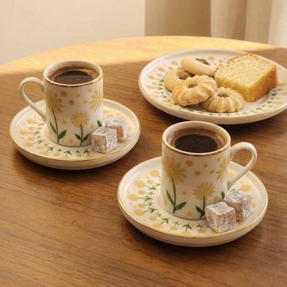 Two cups of coffee with saucers on a wooden table, accompanied by cookies and pastries.