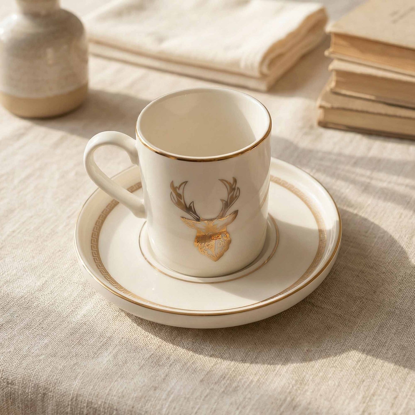 Porcelain cup and saucer with deer design on a textured surface