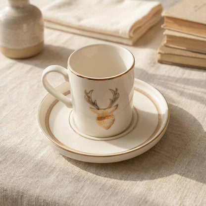 Porcelain cup and saucer with deer design on a textured surface