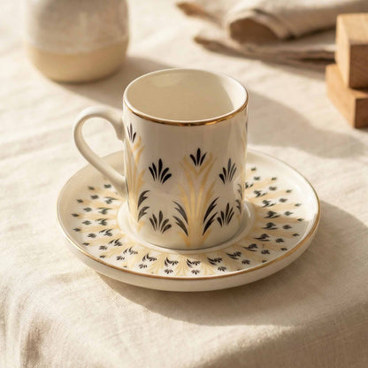 Porcelain cup and saucer with decorative patterns on a beige fabric background