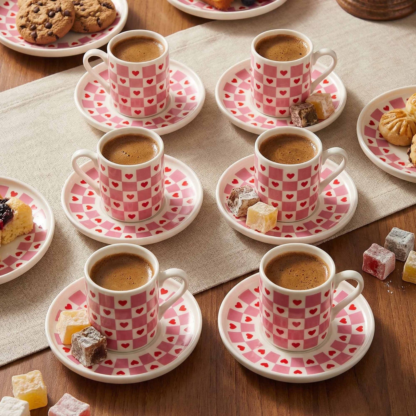 Café au lait served in small cups with saucers on a wooden table.