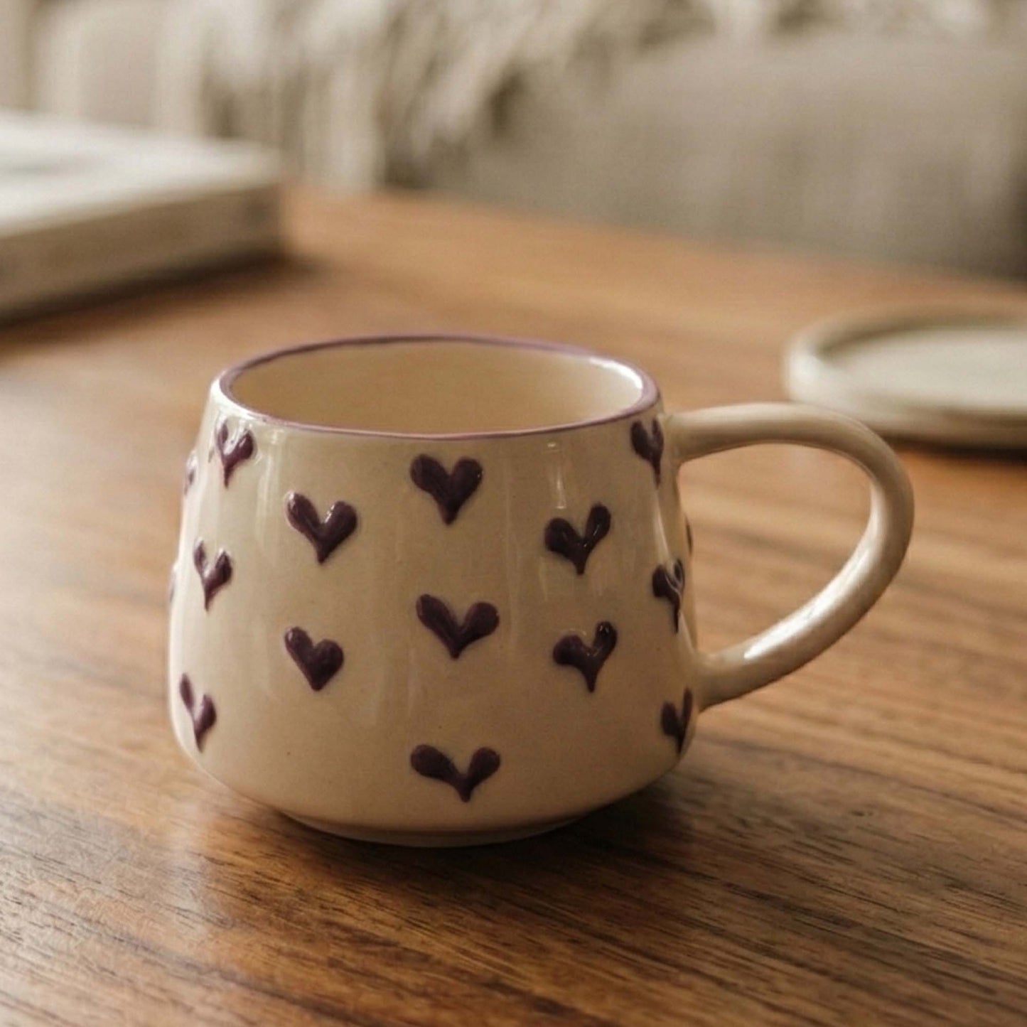 White mug with purple heart patterns on a wooden table