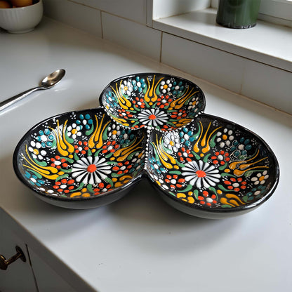 Three colorful ceramic bowls with floral patterns on a white countertop.