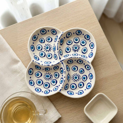 Ceramic snack plate with blue patterns on a wooden table with a cup of tea.