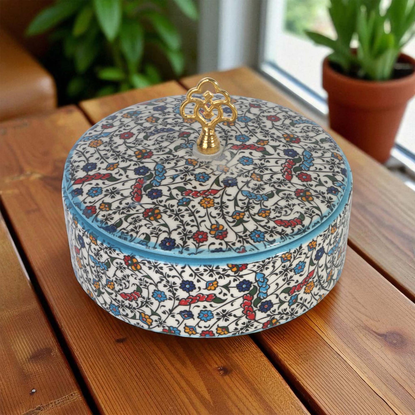 Decorative sugar bowl with floral pattern on a wooden surface