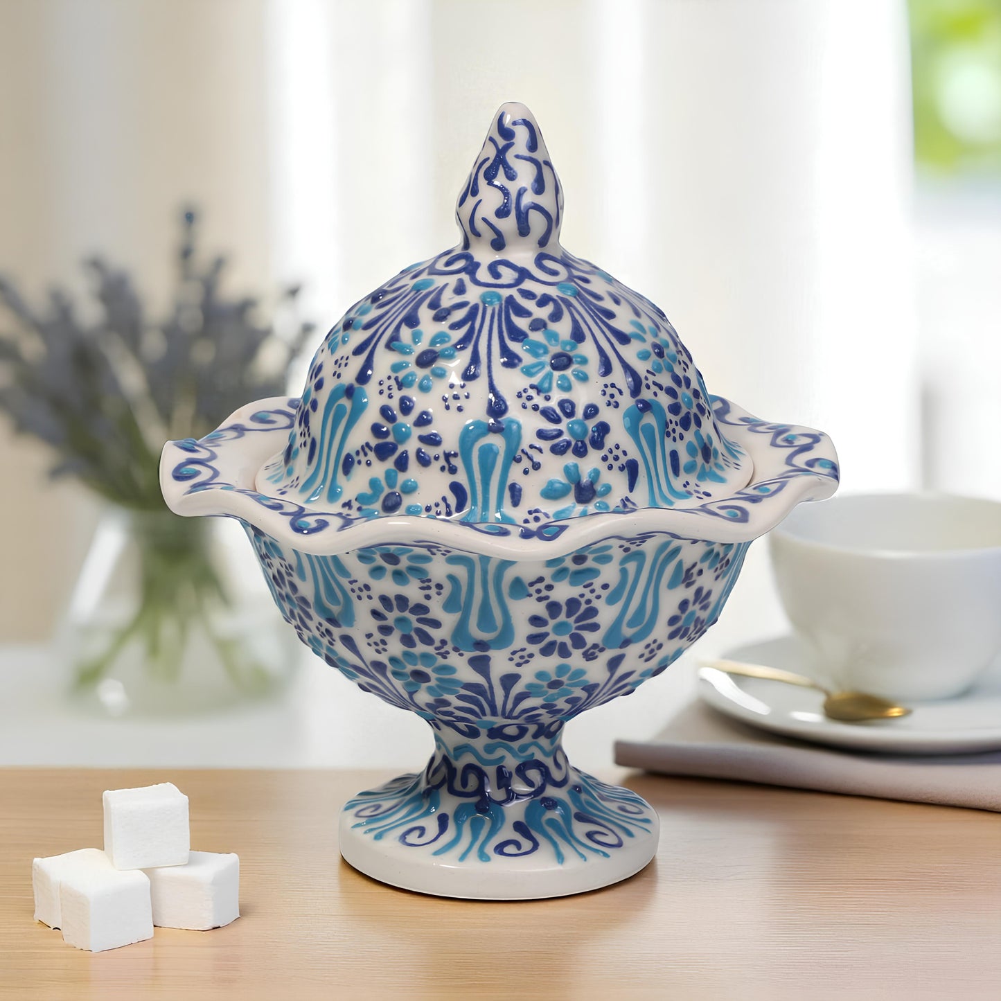 Decorative blue and white ceramic sugar bowl on a table with a blurred background