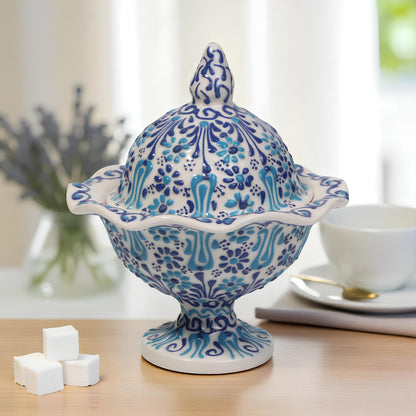 Decorative blue and white ceramic sugar bowl on a table with a blurred background