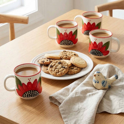 Three floral mugs with coffee and cookies on a wooden table