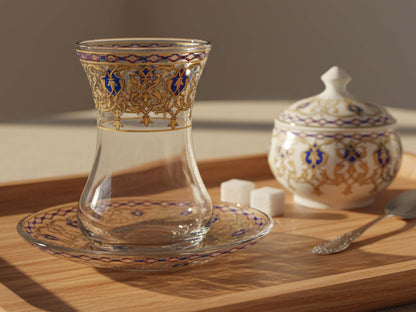 Decorative glass with gold and blue patterns on a wooden surface