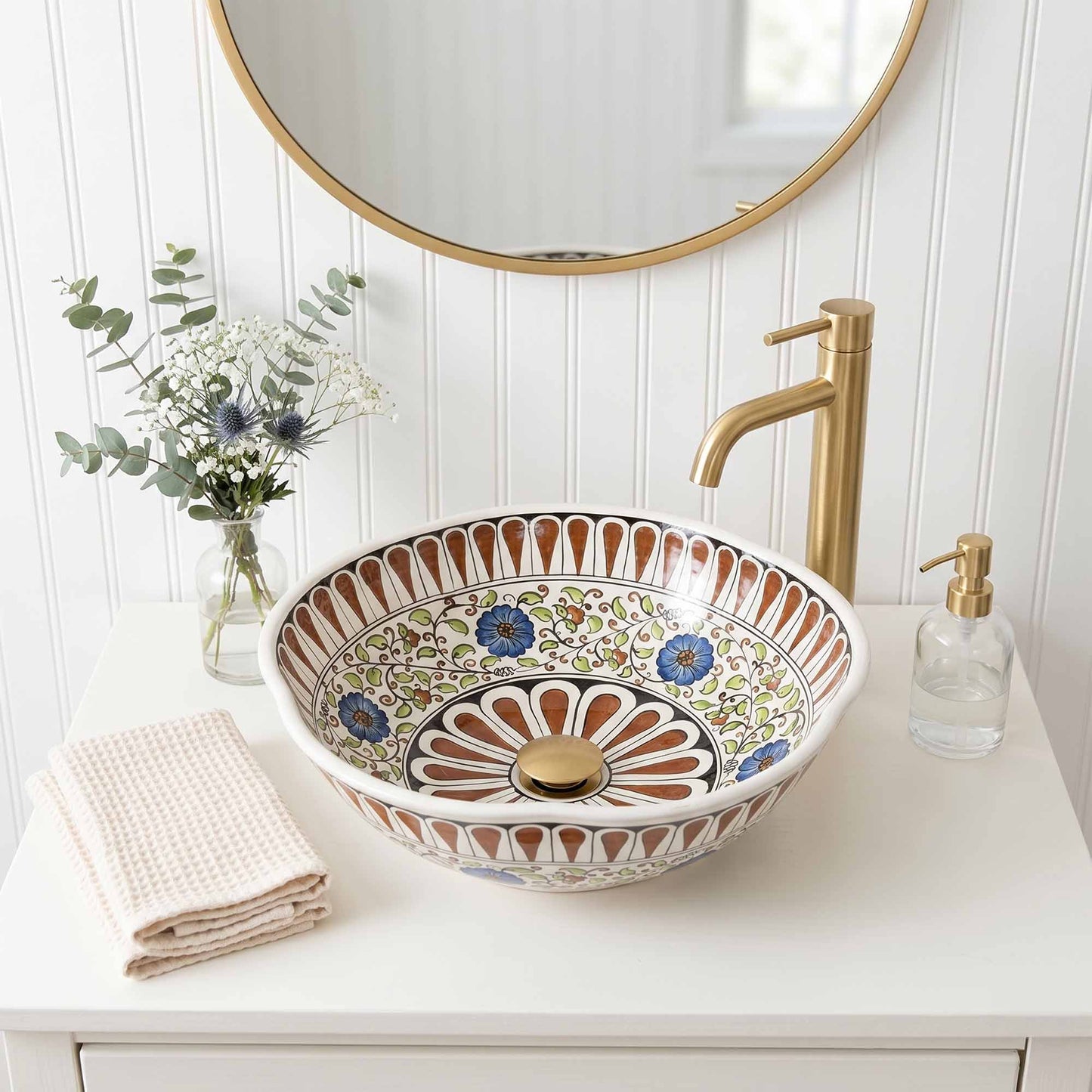 Decorative ceramic sink with floral patterns on a bathroom counter.