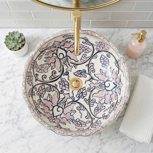 Decorative bathroom sink with floral patterns on a marble countertop.