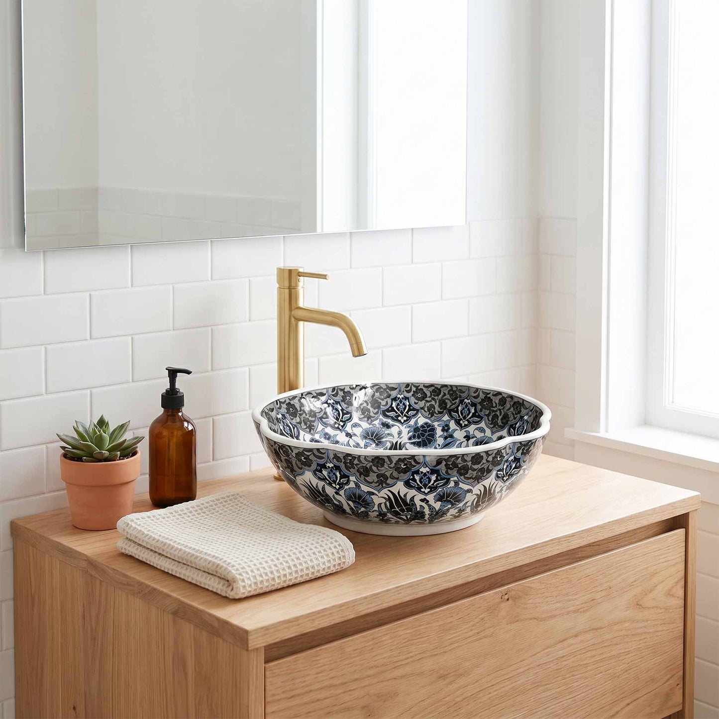 Bathroom vanity with floral-patterned ceramic sink, gold faucet, and decorative elements.