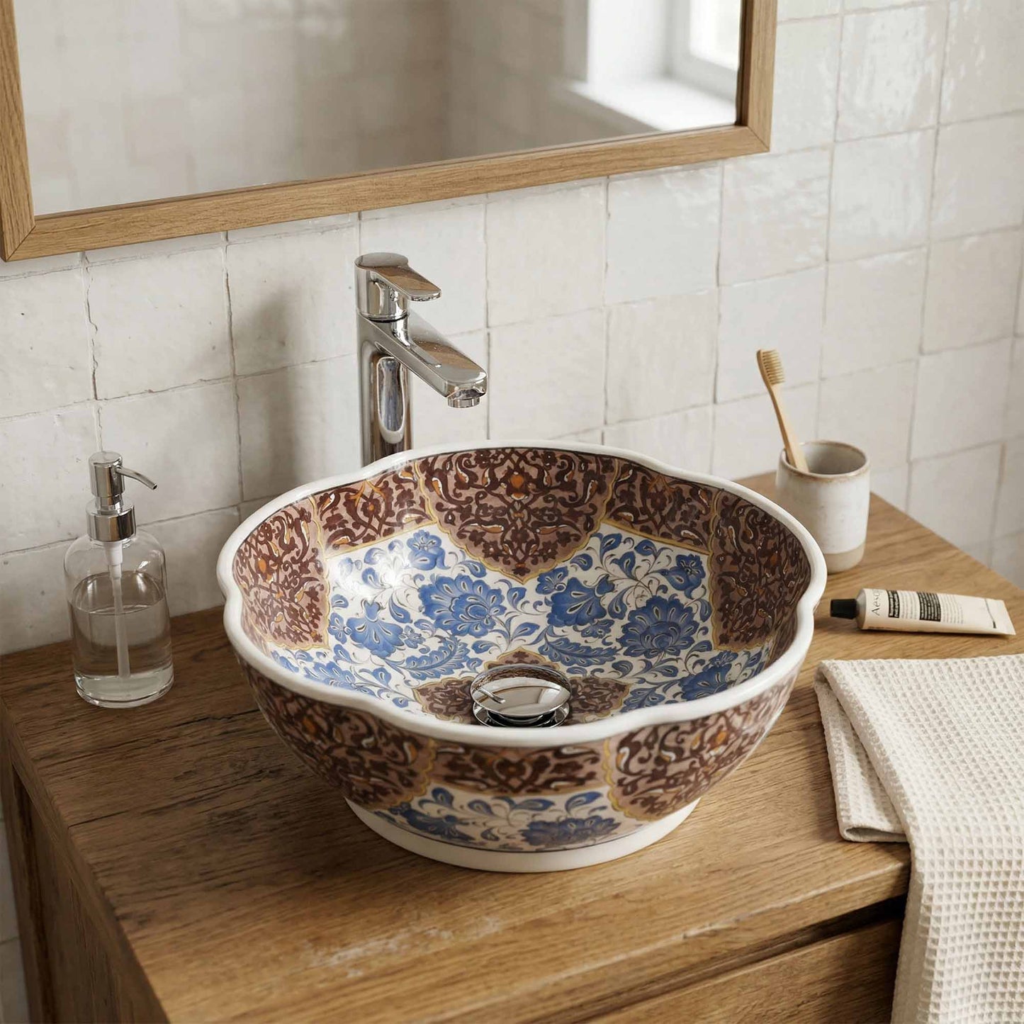 Decorative floral-patterned ceramic sink on a wooden vanity with bathroom accessories.