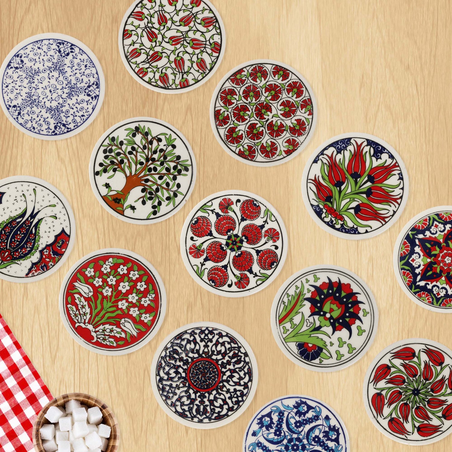 Decorative ceramic coasters with floral and geometric patterns on a wooden surface.