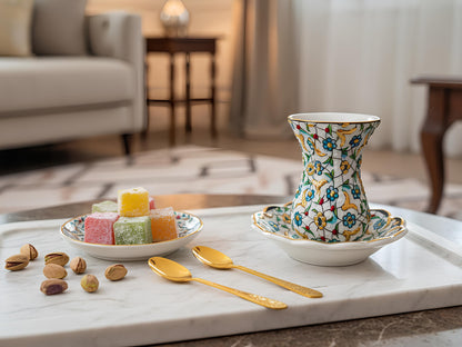 Decorative tea set with a colorful teapot and plates on a marble surface in a living room.