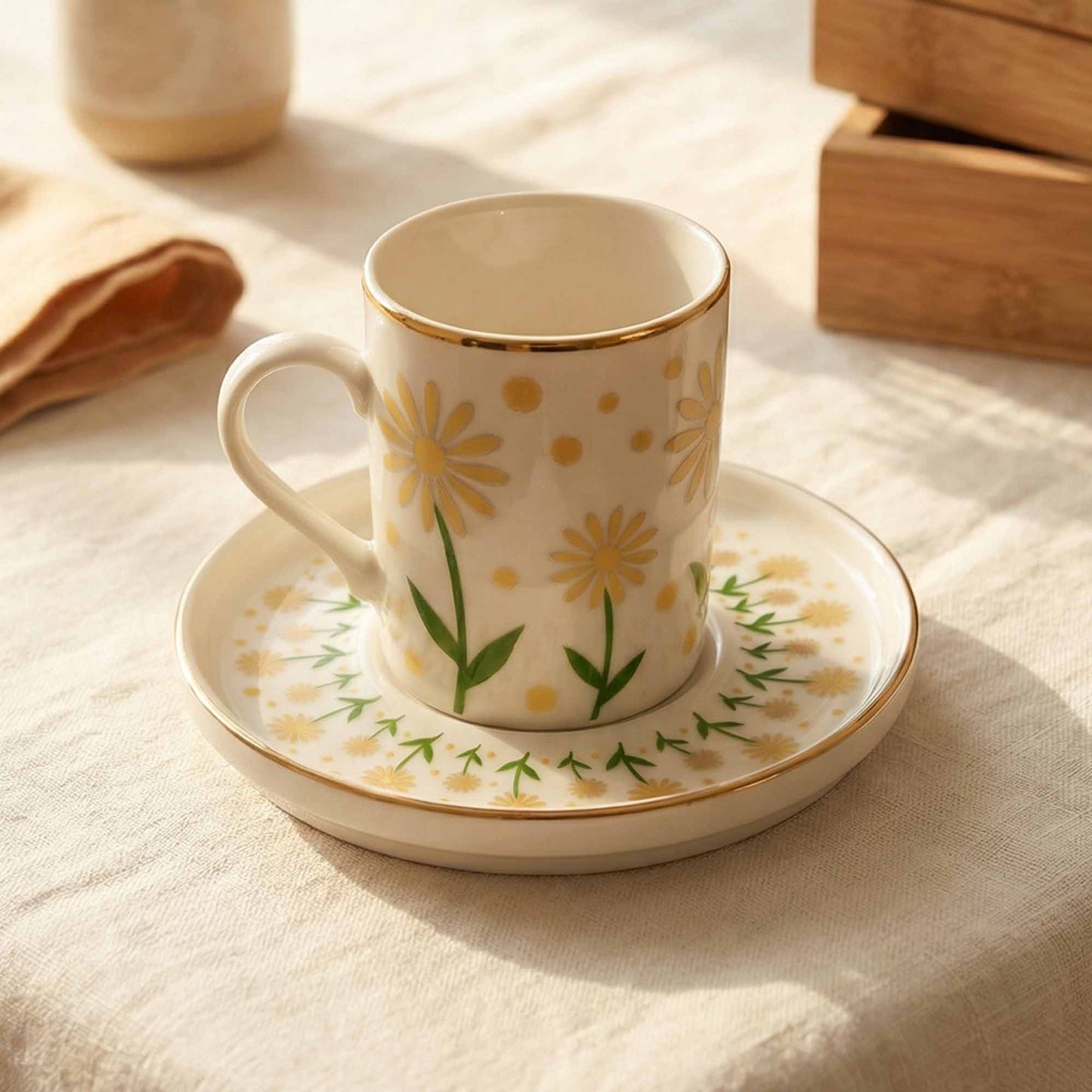 Porcelain mug with floral design on a matching saucer, placed on a textured surface.