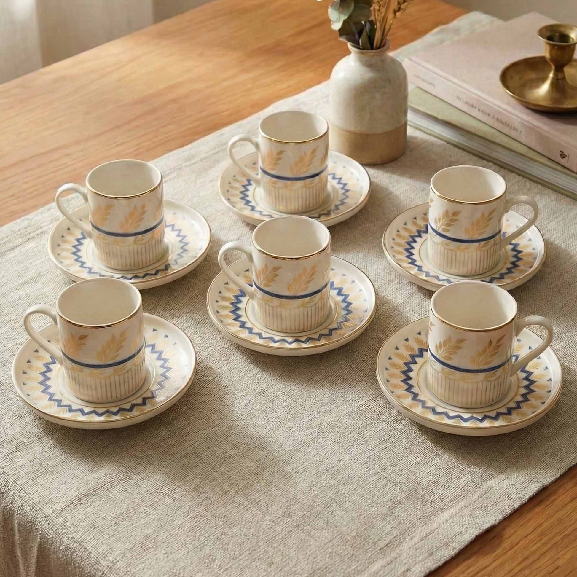 Set of porcelain cups and saucers on a table with a textured tablecloth.