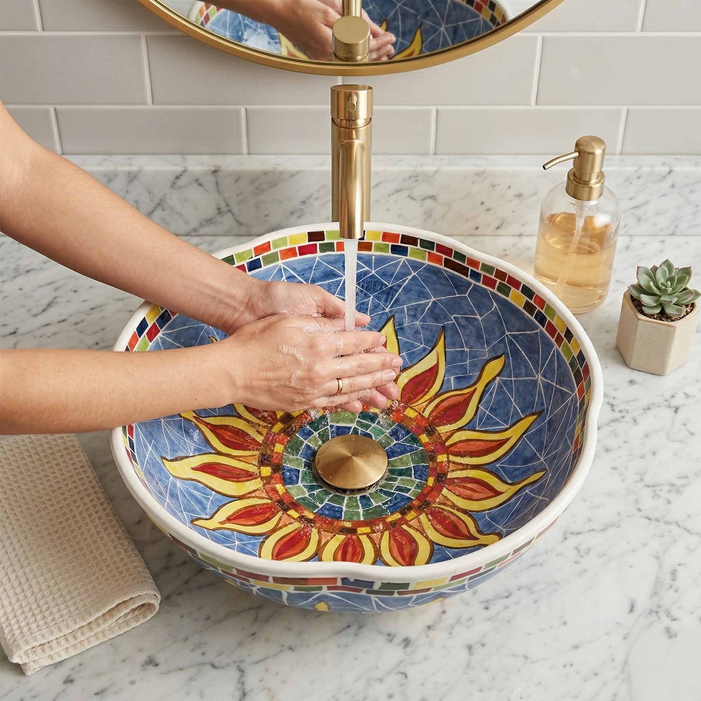 Person washing hands under a colorful sink with a decorative design.