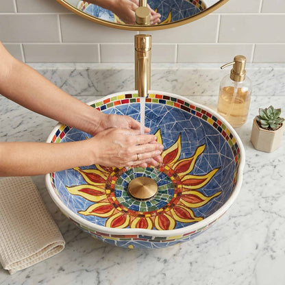 Person washing hands under a colorful sink with a decorative design.