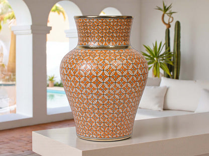 Decorative vase with geometric pattern on a table in an outdoor setting